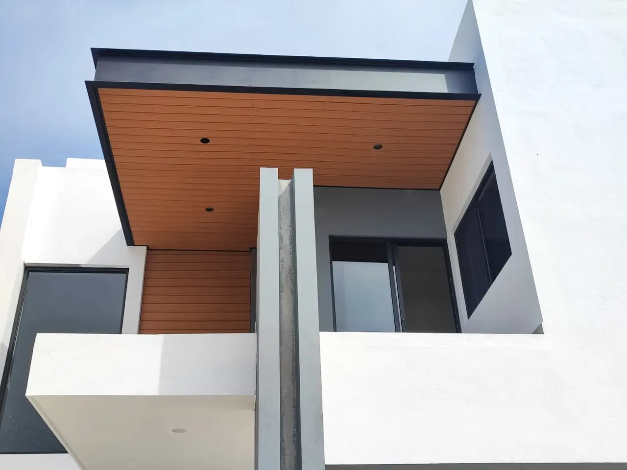 Techo con acabado de deck sintético en la terraza de la fachada de una casa