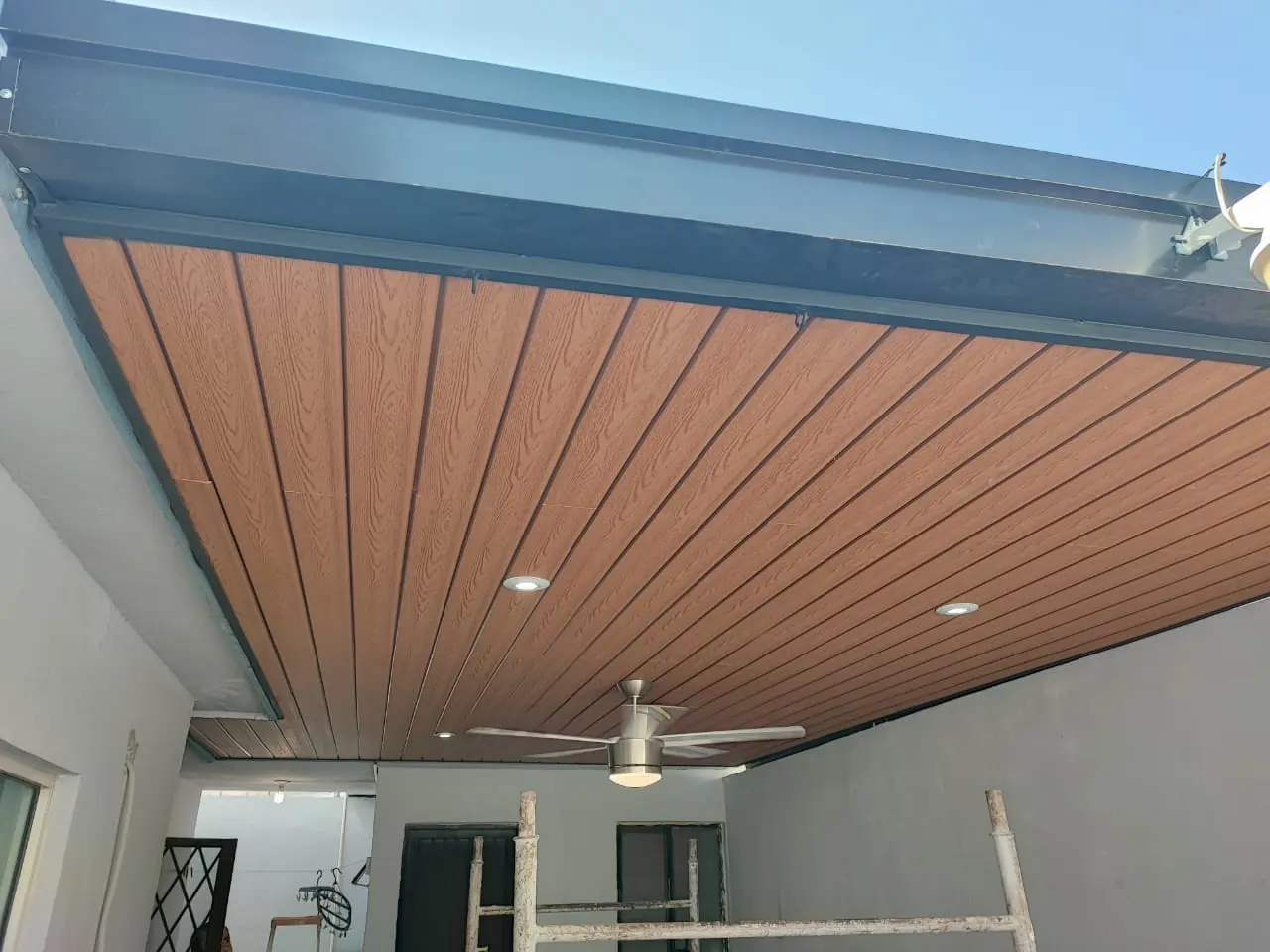 Techo de deck sintético con ventilador y spots sobre un patio