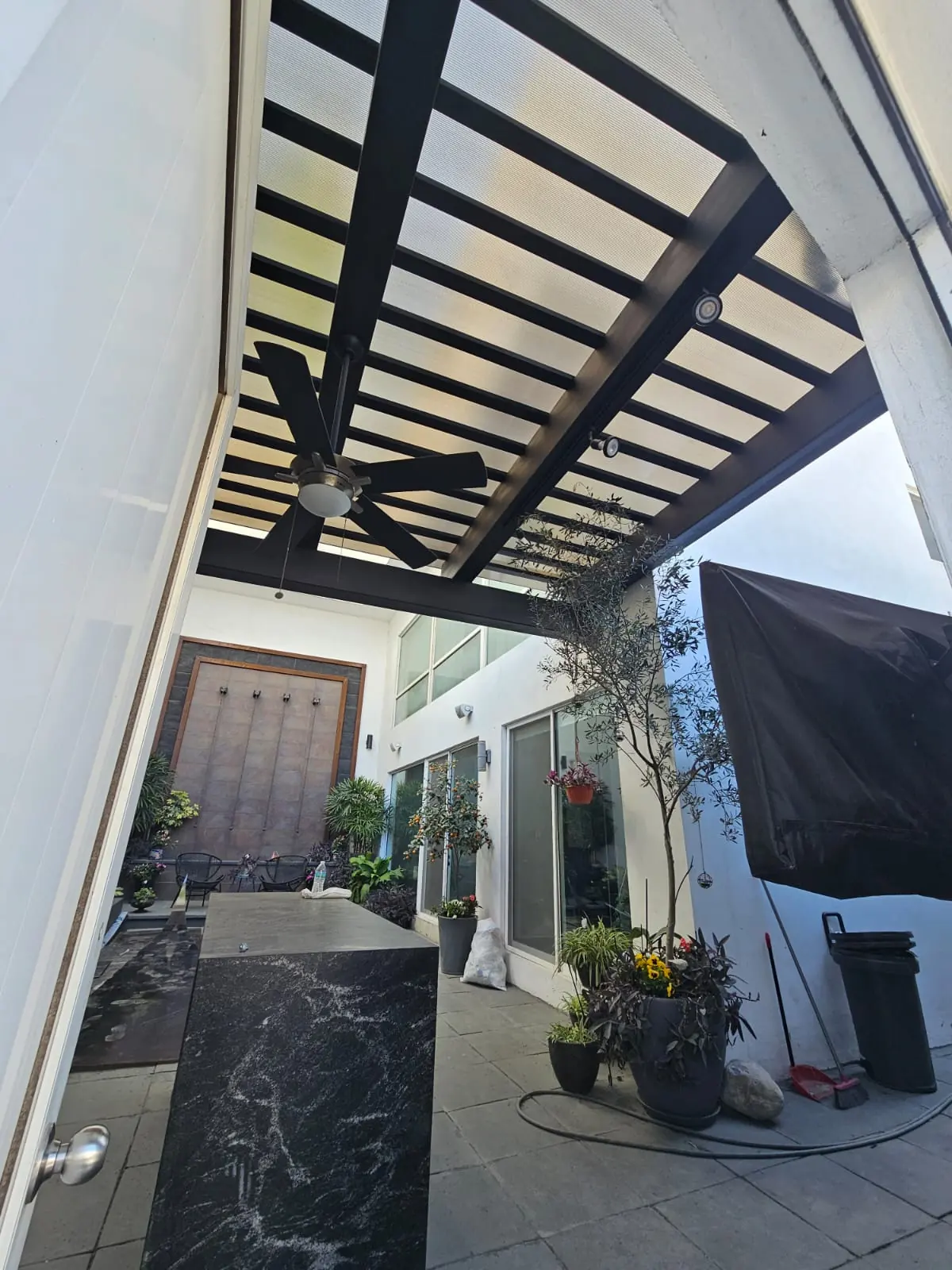 Ventilador de techo bajo la cubierta de policarbonato en el patio