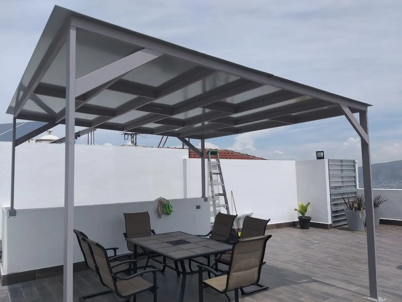 Cubierta de policarbonato sobre el comedor de una terraza en azotea