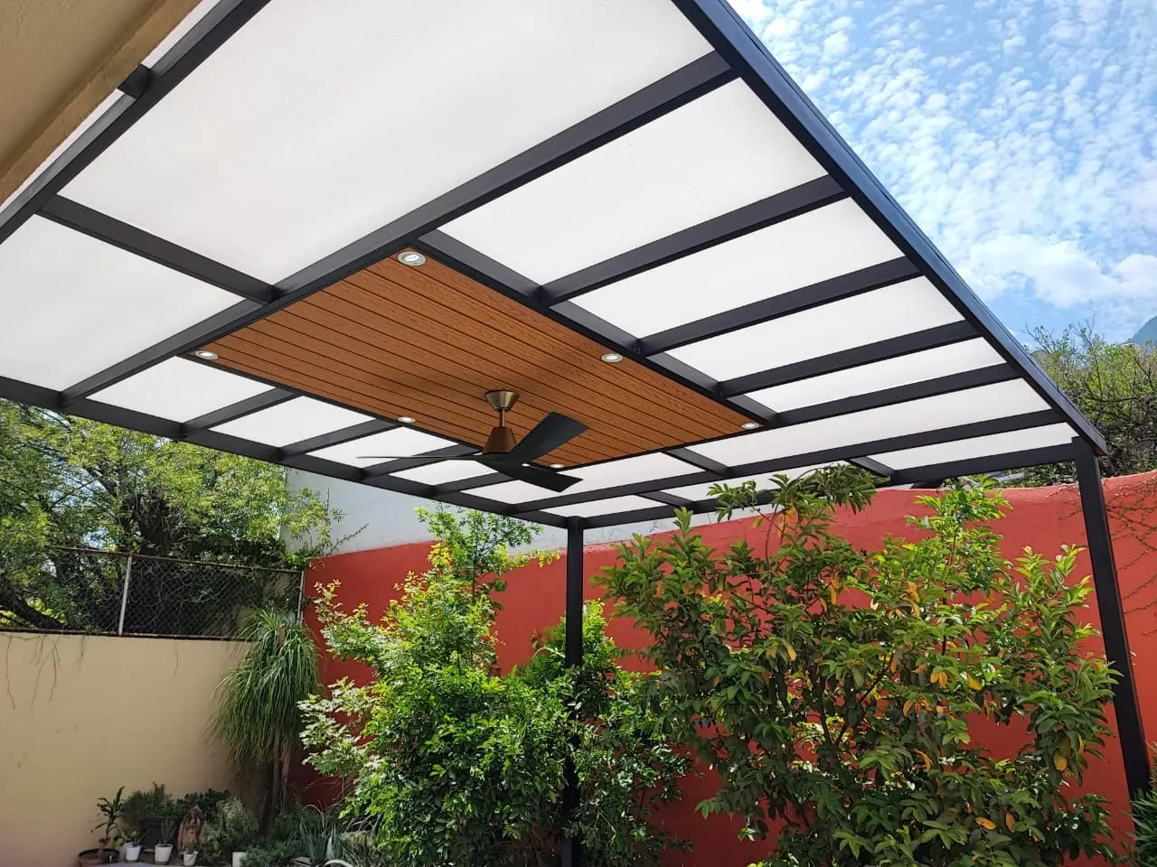 Vista desde el jardín del techo combinado de policarbonato y deck sintético