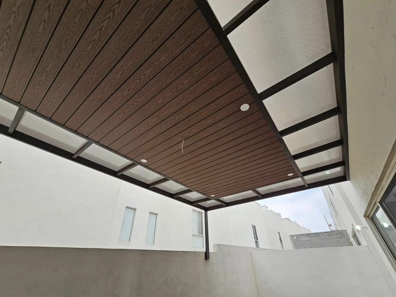 Detalle del deck sintético y la estructura metálica en el patio lateral