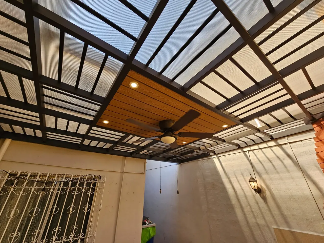 Detalle del ventilador de techo y spots en la zona de deck sintético