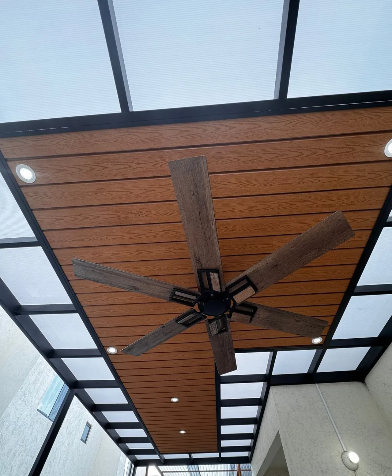 Ventilador de techo sobre deck sintético rodeado de policarbonato